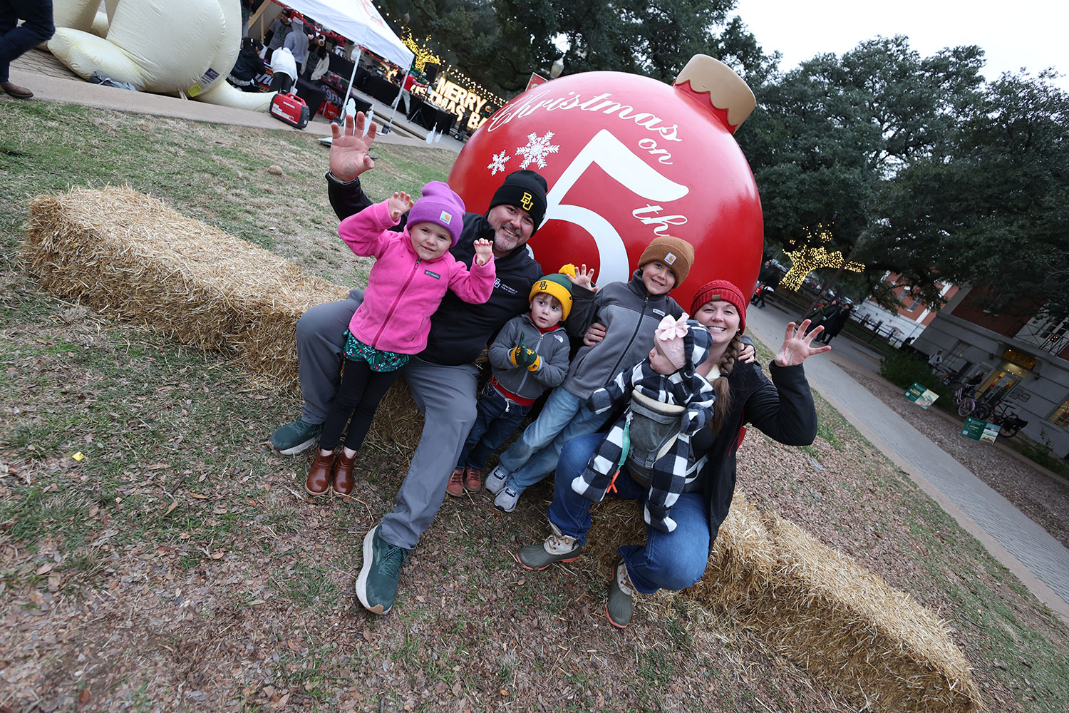 A family of six in front of the 5th St. red ornament